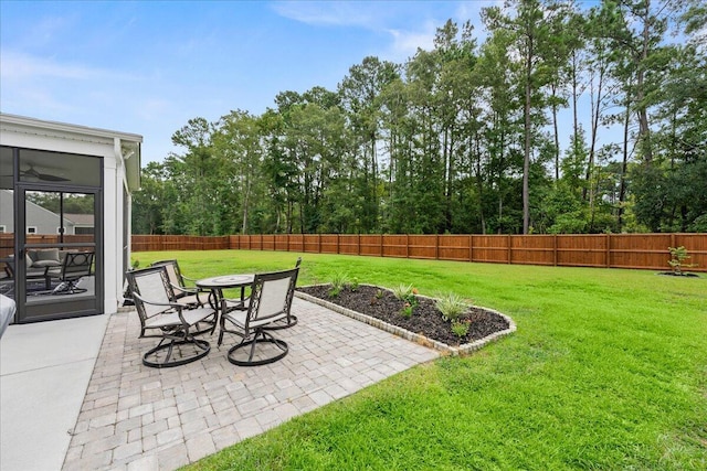 view of yard with a patio area, a fenced backyard, and a sunroom