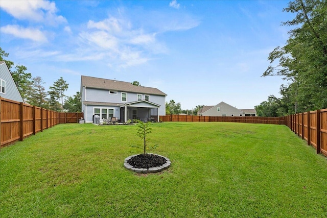 rear view of house featuring a fenced backyard and a yard