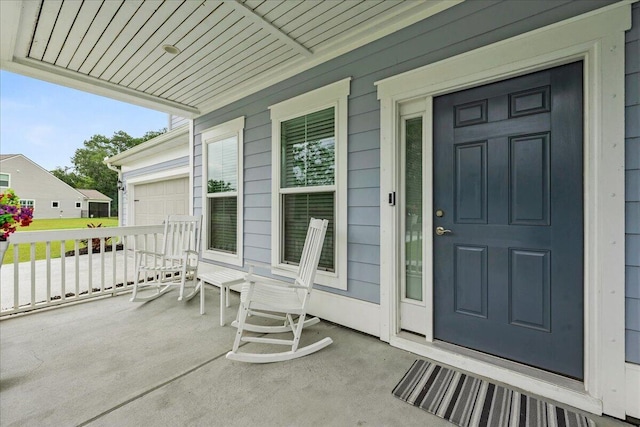 view of exterior entry featuring a garage and covered porch