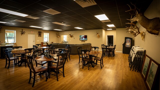 dining space featuring light hardwood / wood-style flooring and a paneled ceiling