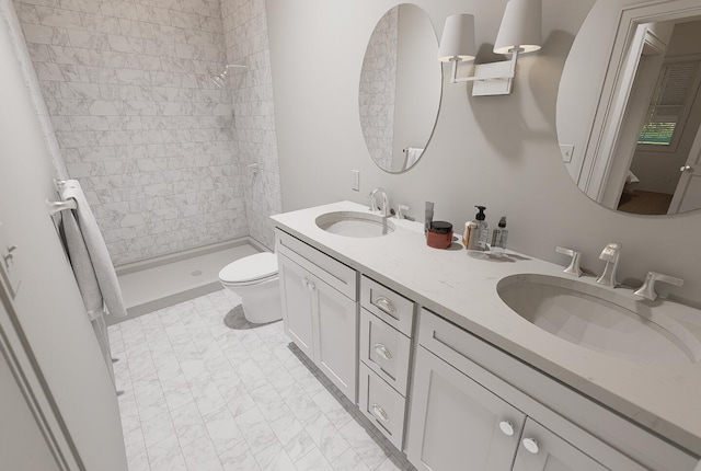 full bathroom with a tile shower, double vanity, toilet, and a sink