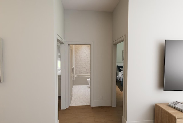 corridor with baseboards and hardwood / wood-style flooring