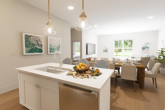 kitchen featuring a sink, light wood-type flooring, open floor plan, dishwasher, and decorative light fixtures