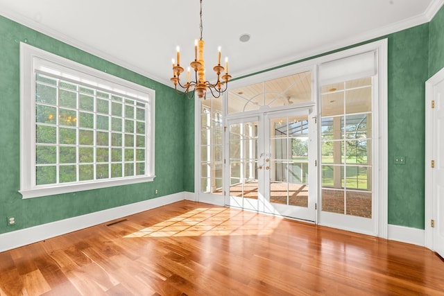 unfurnished dining area with plenty of natural light, a chandelier, and hardwood / wood-style flooring