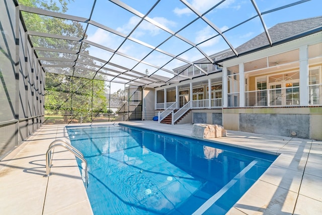 view of pool with glass enclosure and a patio area