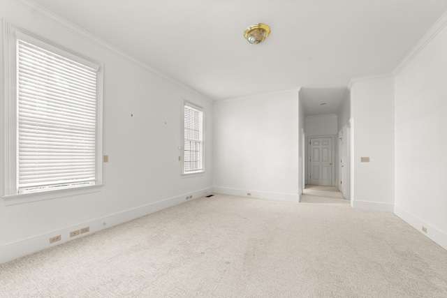 unfurnished room featuring plenty of natural light, crown molding, and light carpet