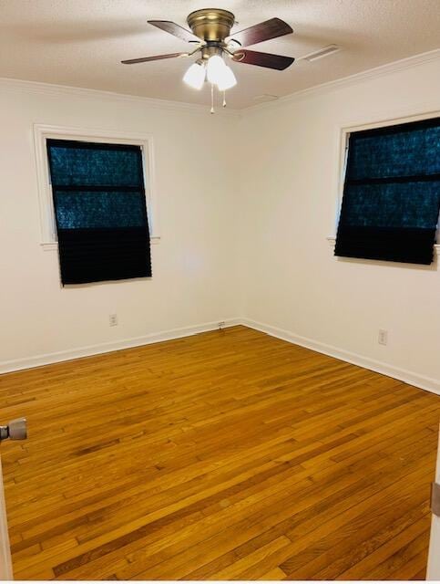empty room featuring crown molding, a ceiling fan, and wood finished floors