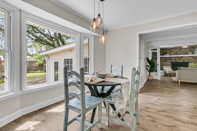 dining room featuring a wealth of natural light, light wood-style flooring, and baseboards