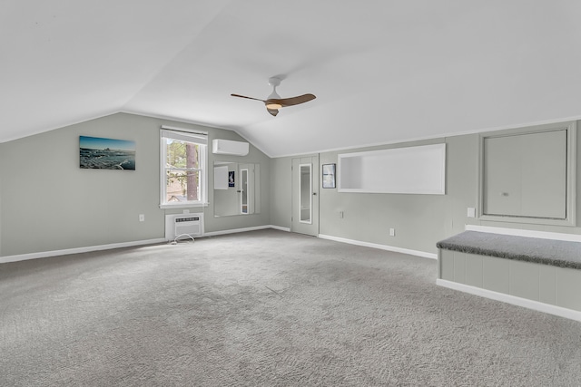 additional living space with ceiling fan, a wall mounted air conditioner, vaulted ceiling, and carpet floors