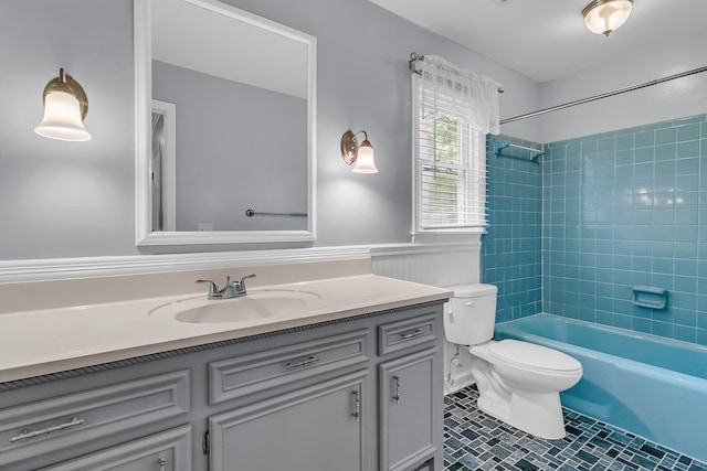 full bathroom featuring a wainscoted wall, toilet, bathing tub / shower combination, tile patterned floors, and vanity