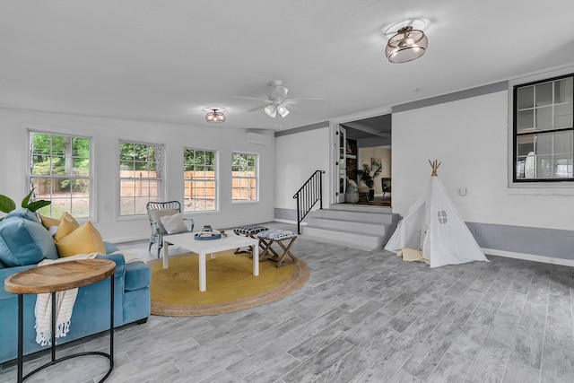 interior space with baseboards, wood finished floors, a wealth of natural light, and ceiling fan