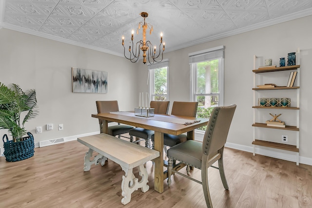 dining space with an ornate ceiling, light wood-style floors, and a notable chandelier