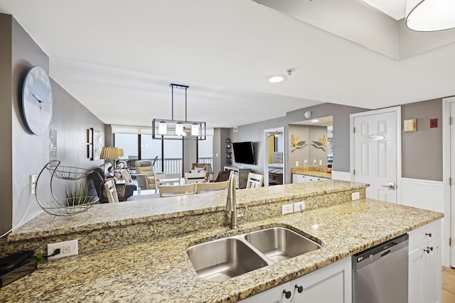 kitchen with dishwasher, sink, white cabinets, hanging light fixtures, and light stone countertops