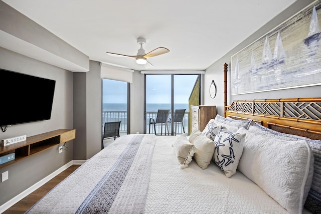 bedroom with ceiling fan, access to exterior, a water view, wood-type flooring, and expansive windows