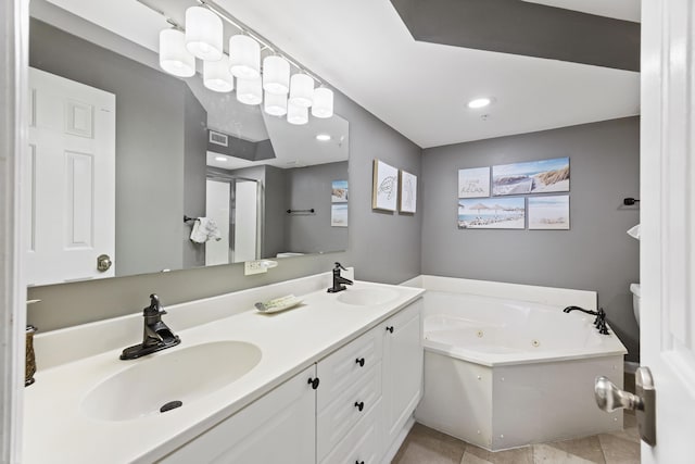 bathroom with a tub to relax in, toilet, tile patterned flooring, and vanity