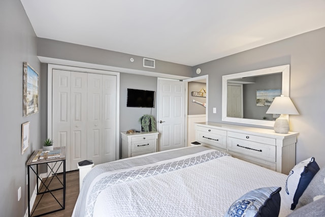 bedroom featuring dark wood-type flooring and a closet