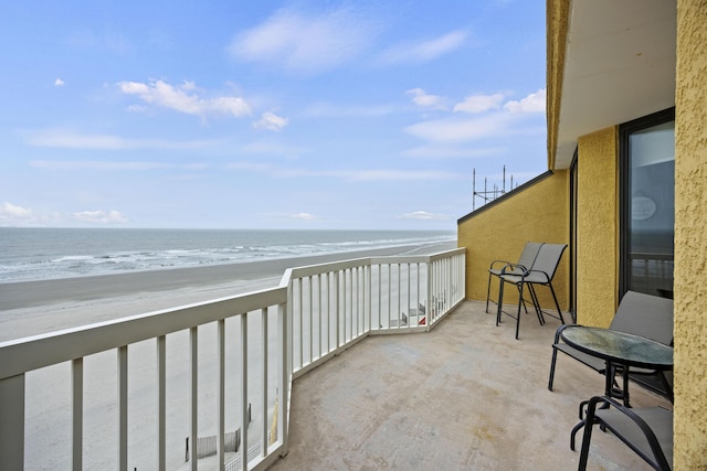 balcony featuring a water view and a beach view