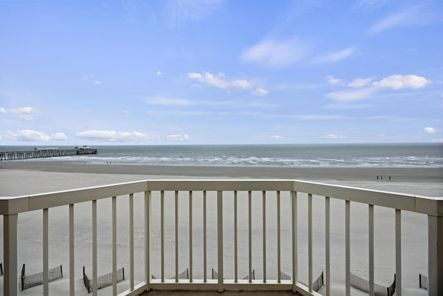 balcony with a water view and a beach view