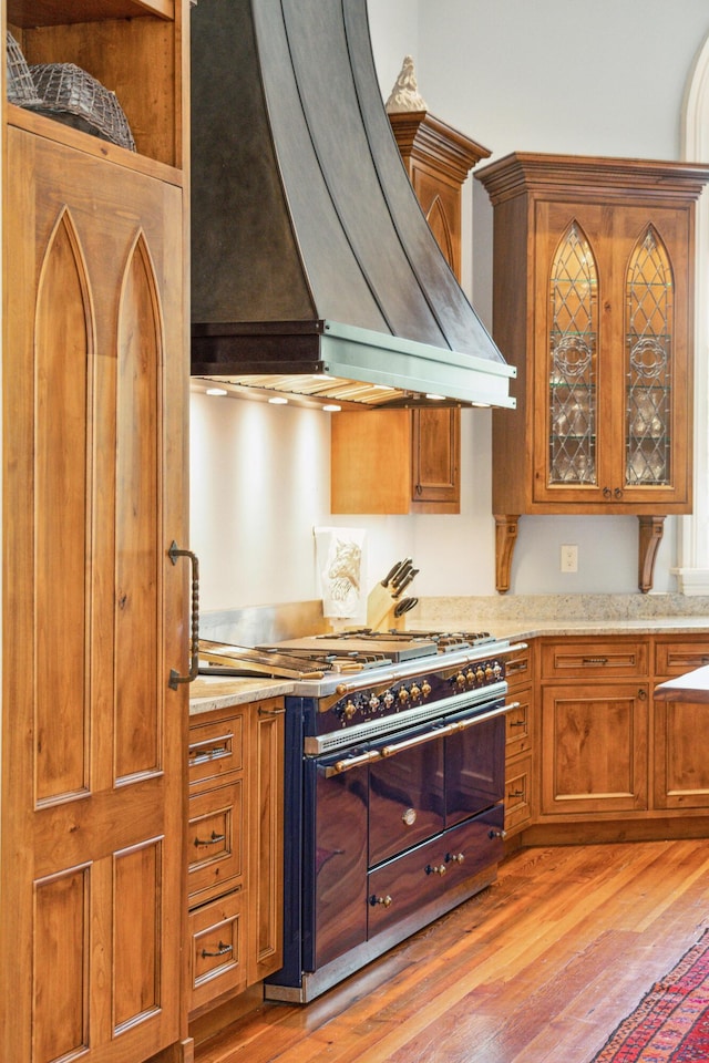 174 N Shelmore Blvd, Mount Pleasant, SC 29464 - kitchen with custom exhaust hood, double oven range, light wood finished floors, and brown cabinets