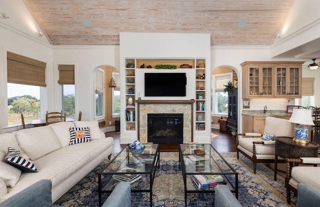 living room featuring built in shelves, a fireplace, wood ceiling, and lofted ceiling