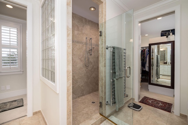 bathroom with crown molding, tile patterned flooring, and tiled shower