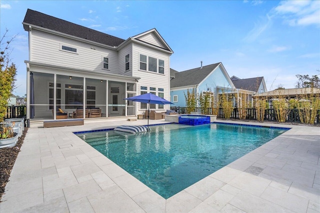 view of pool with a sunroom, a patio area, a pool with connected hot tub, and fence