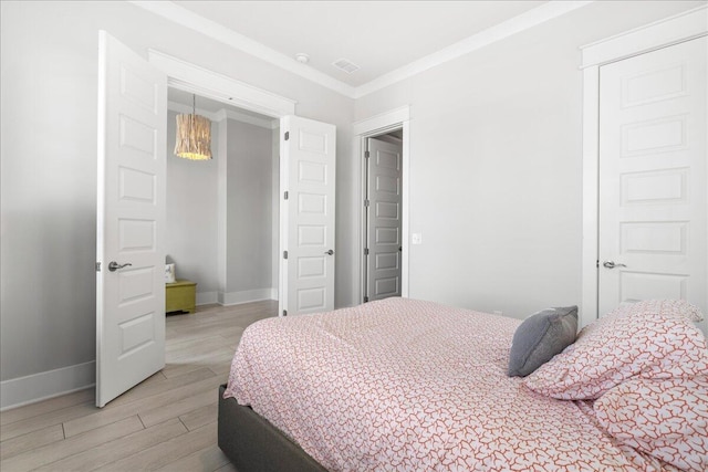 bedroom with ornamental molding, a closet, and light hardwood / wood-style floors