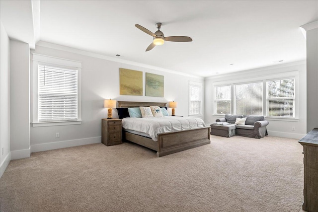 carpeted bedroom with ornamental molding and ceiling fan