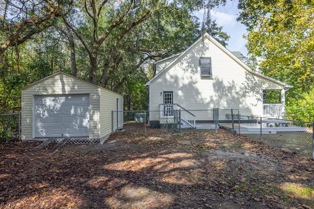 rear view of property with an outbuilding and a garage