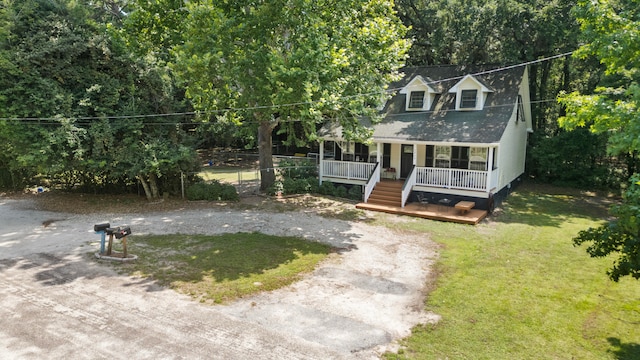 cape cod house featuring a front lawn and covered porch