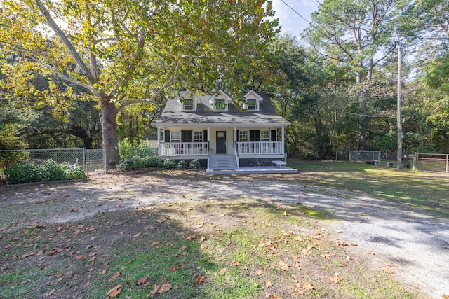 cape cod house featuring covered porch