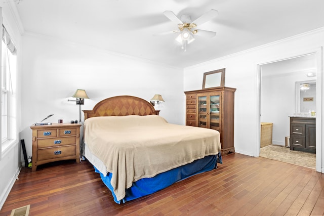 bedroom featuring ceiling fan, ornamental molding, dark wood-type flooring, and ensuite bath