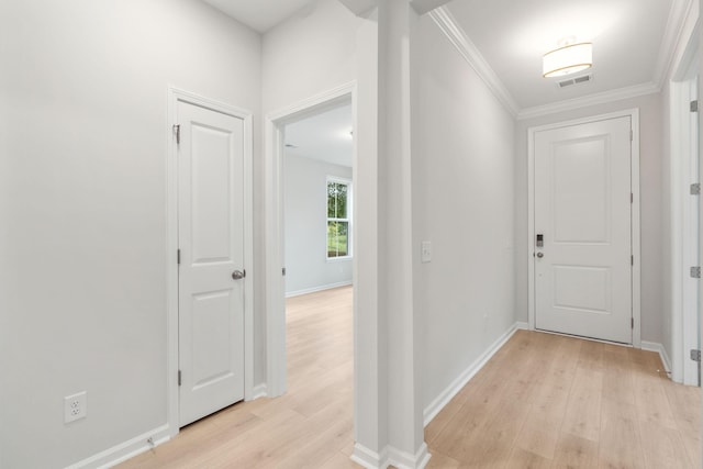 hall with light hardwood / wood-style floors and ornamental molding