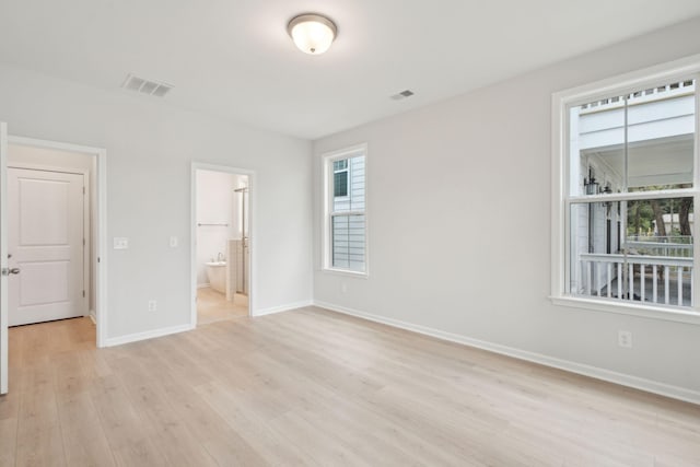 unfurnished bedroom with light wood-type flooring, connected bathroom, and a closet