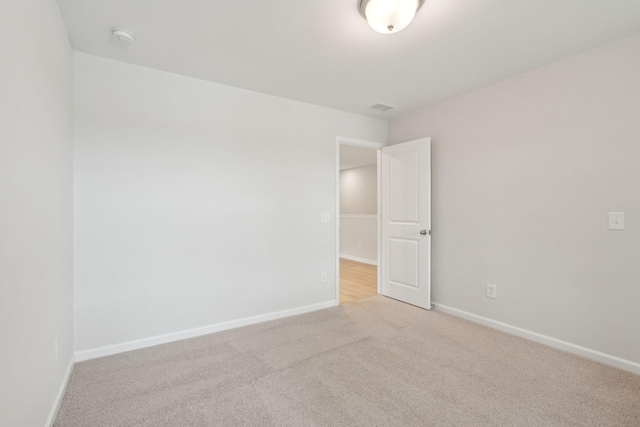 unfurnished room featuring light colored carpet