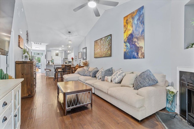 living room with wood-type flooring, ceiling fan, and lofted ceiling