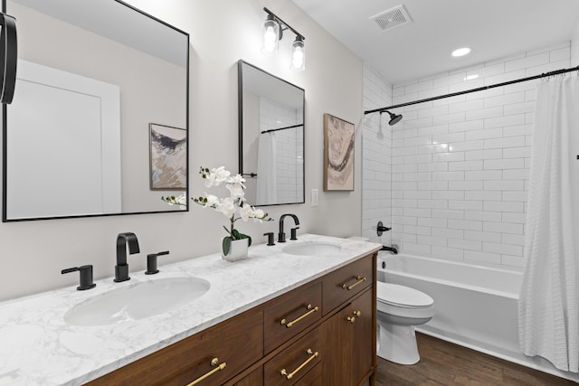 full bathroom with visible vents, a sink, shower / bathtub combination with curtain, and wood finished floors