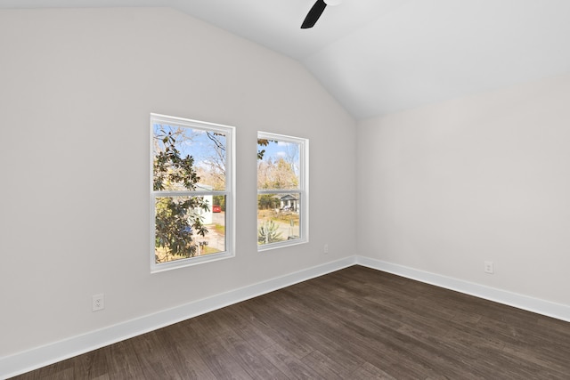 unfurnished room with vaulted ceiling, dark wood-style floors, a ceiling fan, and baseboards