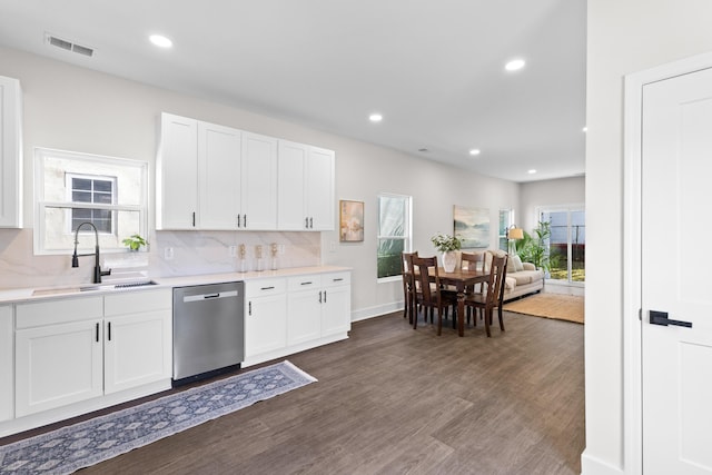 kitchen with tasteful backsplash, visible vents, dishwasher, dark wood-type flooring, and a sink