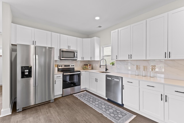 kitchen with stainless steel appliances, visible vents, a sink, and tasteful backsplash