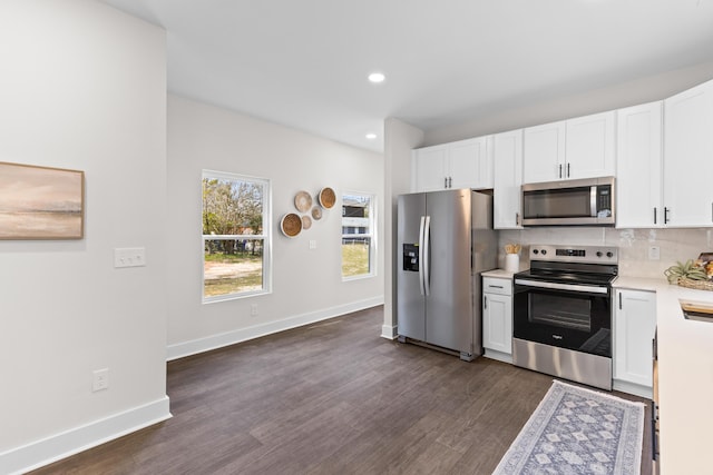 kitchen featuring dark wood-style floors, stainless steel appliances, tasteful backsplash, light countertops, and white cabinets