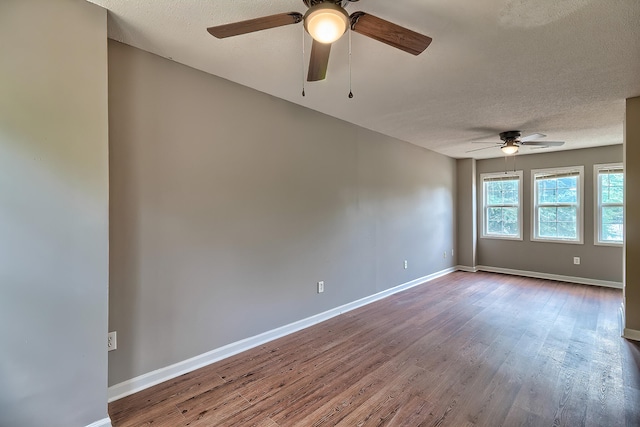 unfurnished room featuring a textured ceiling, wood finished floors, a ceiling fan, and baseboards