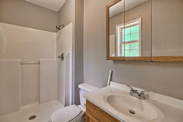 full bathroom with vanity, toilet,  shower combination, and a textured ceiling