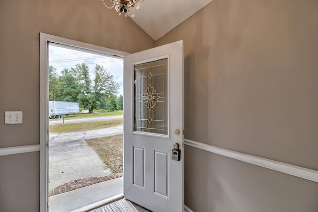 doorway featuring vaulted ceiling and a chandelier