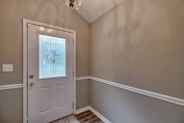 entryway featuring dark wood-style flooring, vaulted ceiling, a textured ceiling, and baseboards