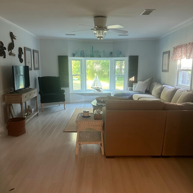 living room with crown molding, ceiling fan, light hardwood / wood-style flooring, and a healthy amount of sunlight