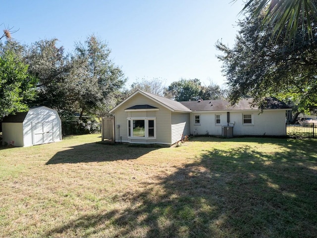 back of property featuring central AC unit, a storage shed, and a yard