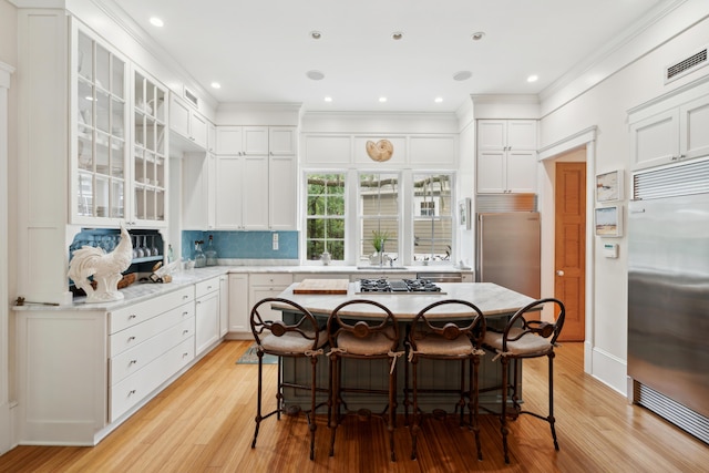 1612 John Fenwick Ln, Johns Island, SC 29455 - kitchen with built in refrigerator, a breakfast bar, light wood-style floors, ornamental molding, and recessed lighting
