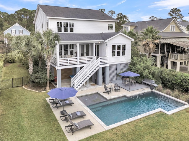 back of house featuring a fenced in pool, a patio area, and a lawn