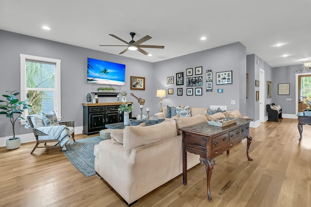 living room featuring light hardwood / wood-style floors, ceiling fan, and a healthy amount of sunlight